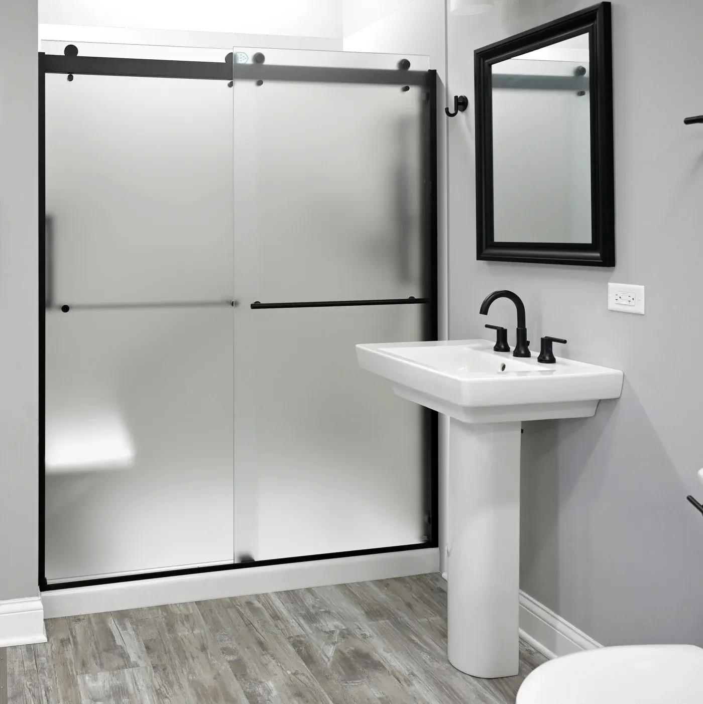 High-end tub-to-shower-conversion walk-in shower with matte black fixtures.